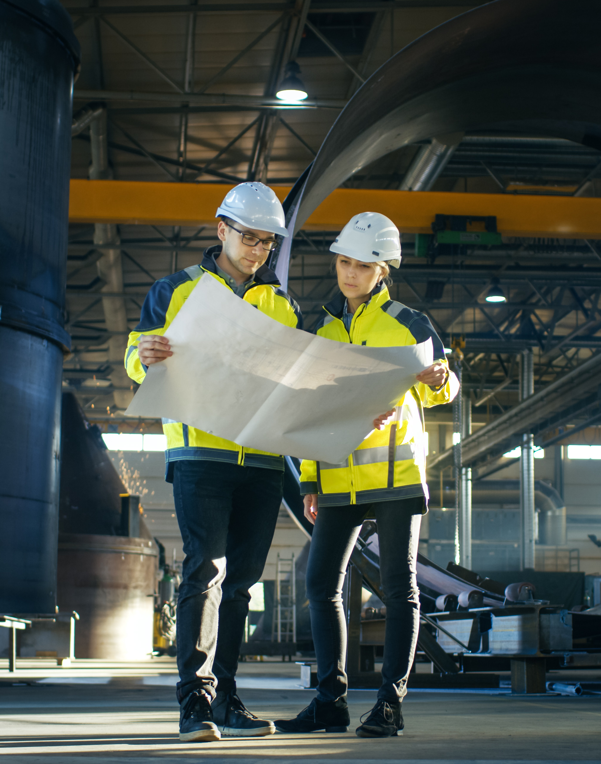 Industrial workers reviewing plans and coordinating workplace safety