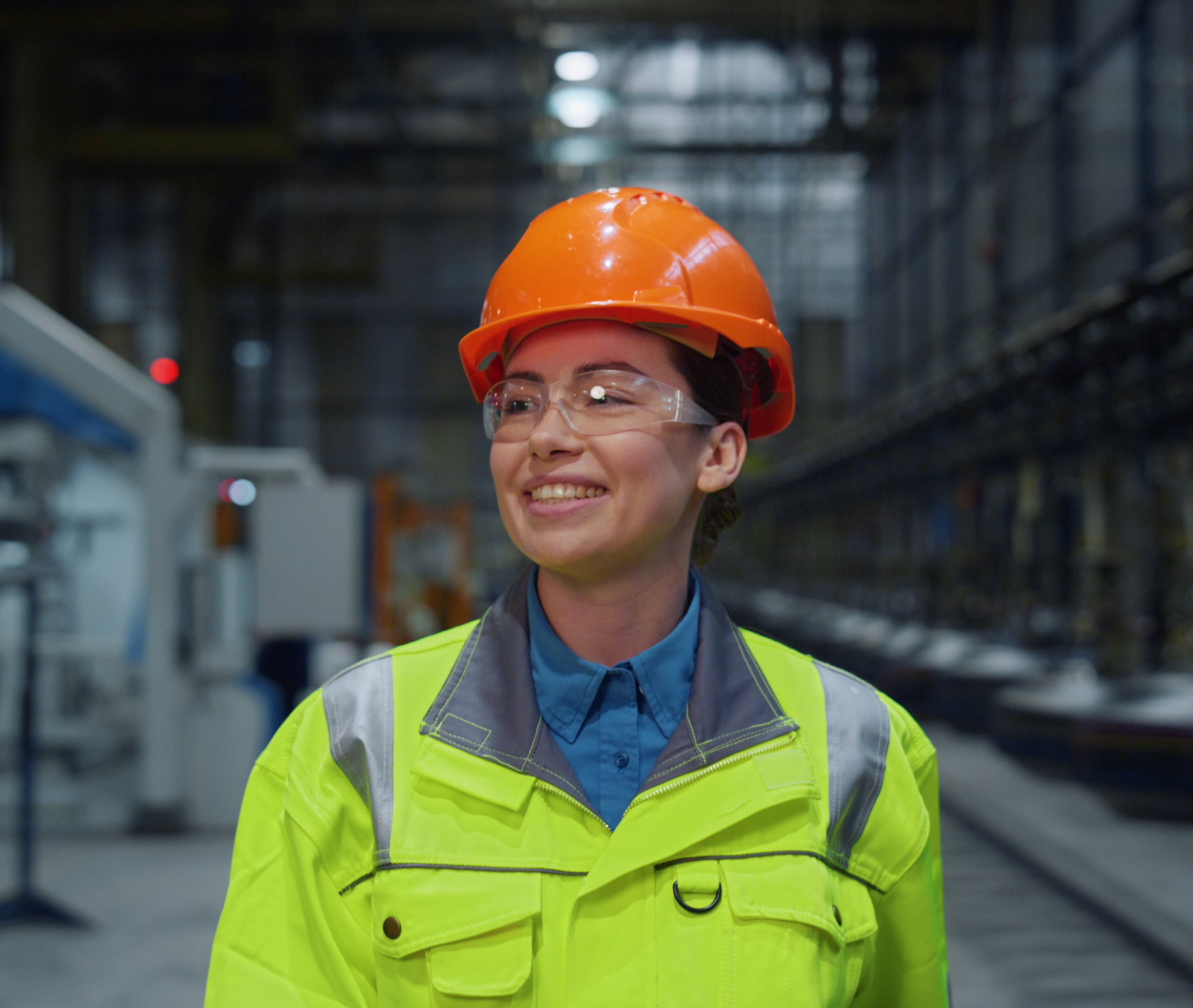 Smiling female worker in safety gear representing patient-centered care